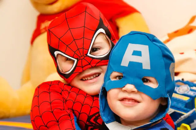 Two children dressed as spiderman and captain america